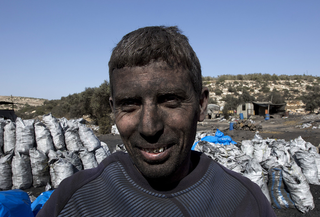عمال فلسطينيون ينتجون الفحم في بلدة يعبد قرب جنين بالضفة الغربية