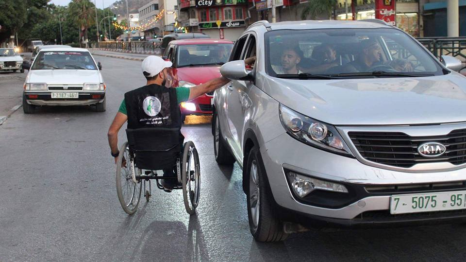 نابلس.. نشطاء من ذوي الإعاقة يوزعون الماء والتمر  على الصائمين
