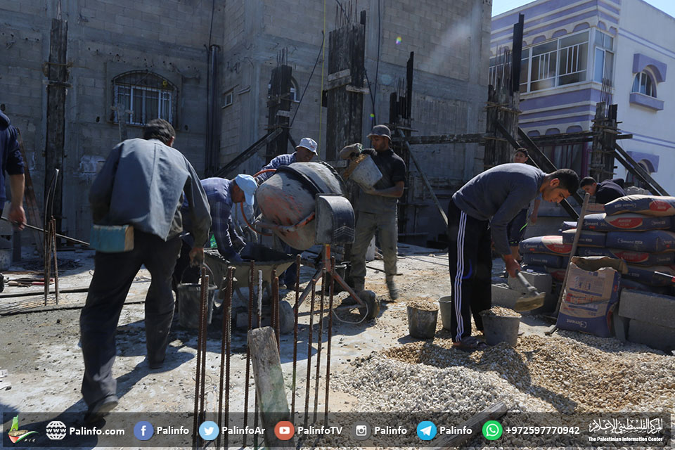 عمال فلسطينيون خلال عملية بناء منزل دمره الاحتلال في حرب 2014