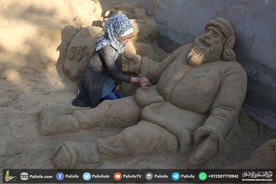 الفنانة رانا الرملاوي تنحت على الرمل بمنزلها في غزة