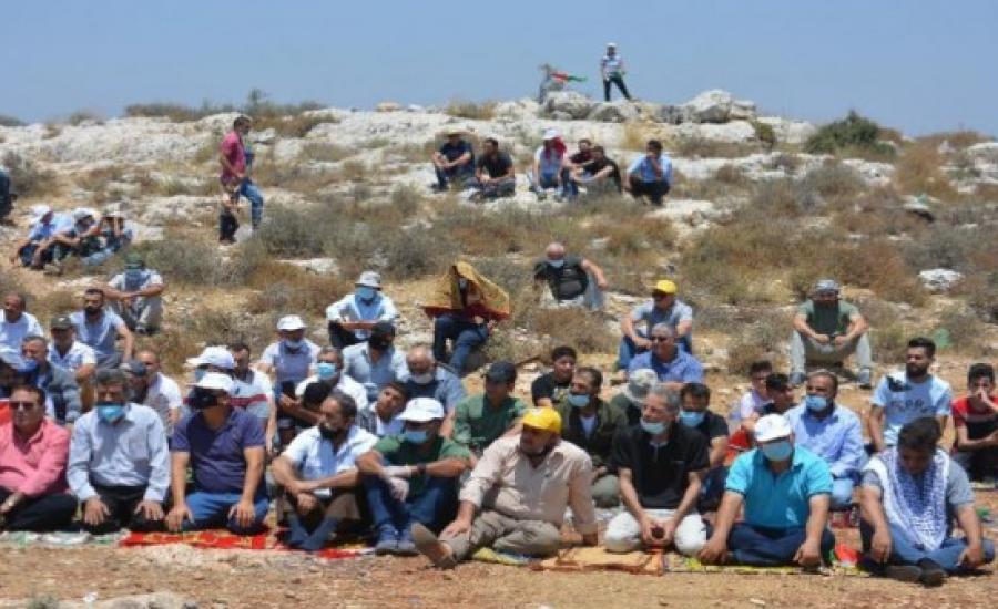 مواطنون يؤدون الجمعة على الأراضي المهددة بالاستيلاء في بلدة حزما