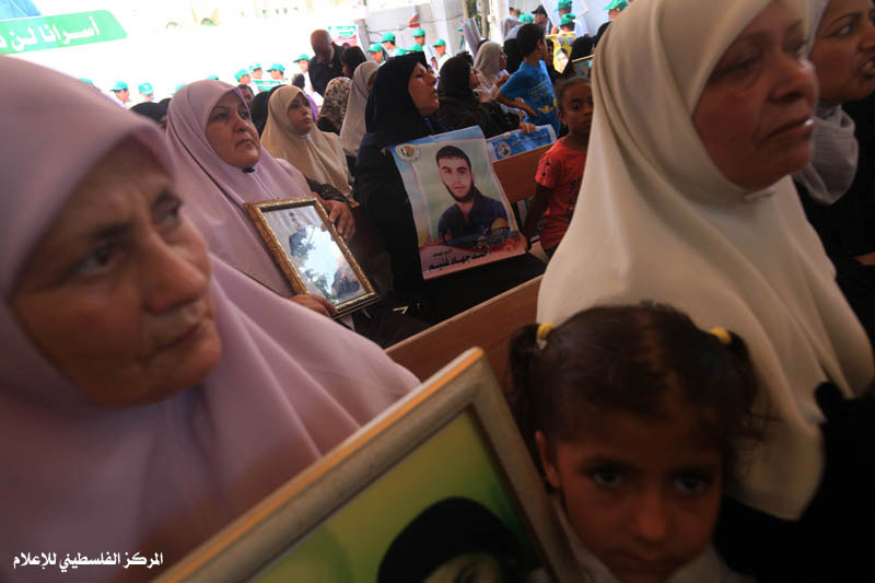 أهالي الأسرى الفلسطينيين داخل السجون الإسرائيلية يرفعون صور أبنائهم بجانب صور الرئيس المصري الجديد