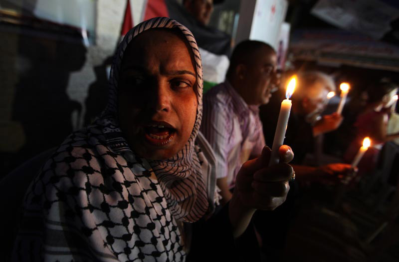 فلسطينيين يشعلون الشموع أمام مقر الصليب الأحمر بغزة تضامن مع الأسرى المضربين عن الطعام