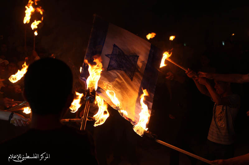 فلسطينيون يطلقون شعلة الحرية ويحرقون العلم الإسرائيلي