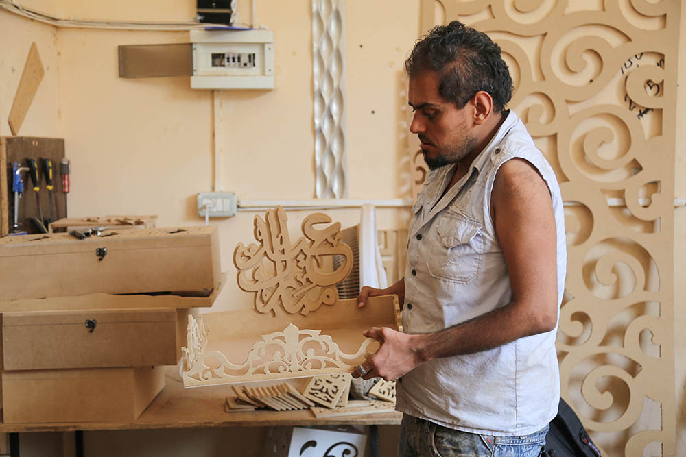 شابان فلسطينيان يتحديان الإعاقة ويعملان في ورشة للنجارة